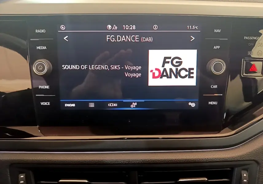 Écran tactile central du tableau de bord du Volkswagen Taigo noir, affichant la radio FG.DANCE en mode DAB.