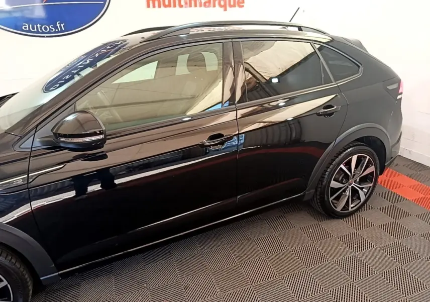 Profil droit du Volkswagen Taigo noir 2023 finition R-Line avec jantes alliage et rétroviseurs électriques.