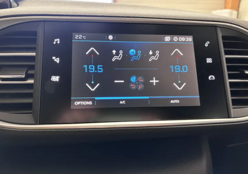 Écran tactile central de la Peugeot 308 gris foncé affichant la climatisation à 19,5°C côté gauche et 19°C côté droit.