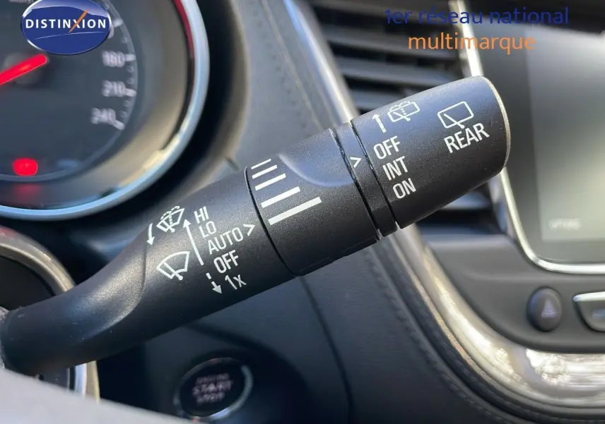 Gros plan sur la manette d'essuie-glace à gauche du volant dans l'habitacle d'un Opel Grandland X blanc toit noir.