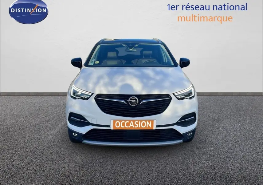 Opel Grandland X blanc toit noir en vue frontale, mettant en valeur sa calandre noire et ses phares LED distinctifs.