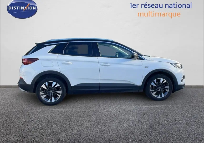 Profil côté gauche d'un Opel Grandland X blanc avec toit noir, roues alliage et lignes modernes visibles.