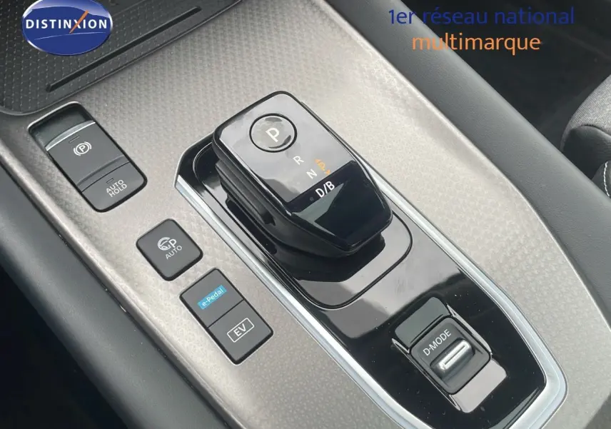 Gros plan sur la console centrale du Nissan Qashqai noir perle, mettant en valeur le sélecteur de boîte automatique et les boutons de conduite.