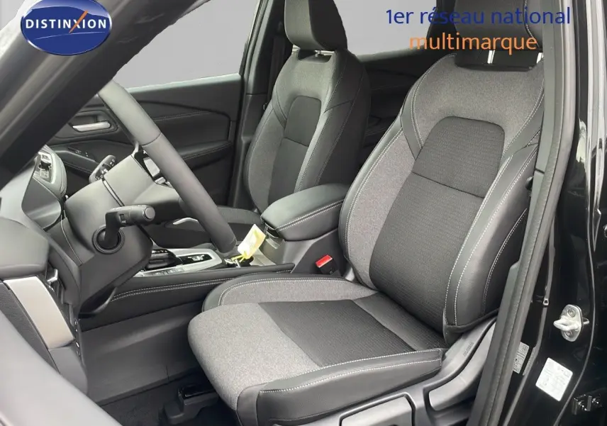 Intérieur du Nissan Qashqai 2025 noir perle, vue côté conducteur sur sièges tissu et cuir gris et noir.