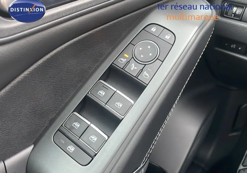 Gros plan sur la commande des vitres côté gauche en cuir noir avec surpiqûres blanches dans un Nissan Qashqai 2025 noir perle métal.