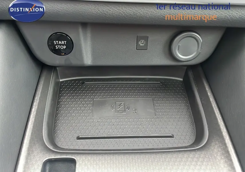 Gros plan sur la console centrale du Nissan Qashqai 2025 noir perle, montrant le bouton start/stop et le chargeur sans fil.