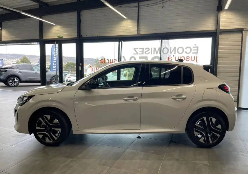Peugeot 208 blanche vue de profil côté gauche, avec jantes alliage bi-tons et poignées couleur carrosserie.
