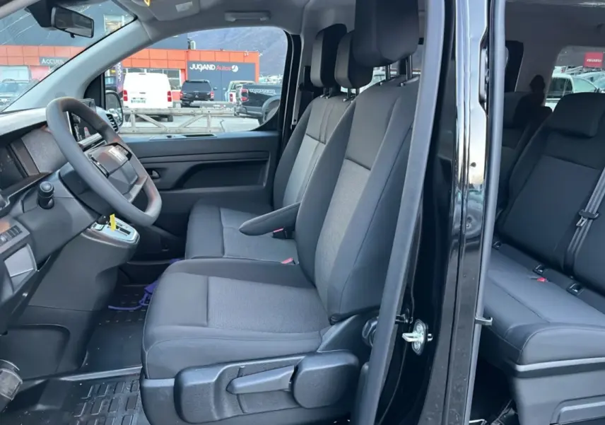Vue intérieure côté gauche du FIAT Scudo Fourgon noir 2025, montrant les sièges avant et arrière avec accoudoir central.