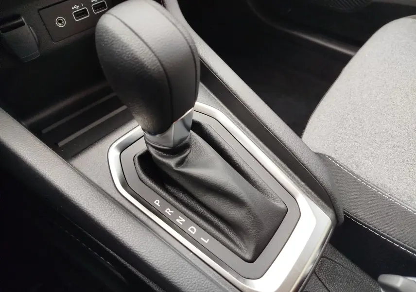 Gros plan sur le levier de vitesses automatique noir de la Renault Clio TCE 90CH X-TRONIC Evolution 2025, intérieur gris.