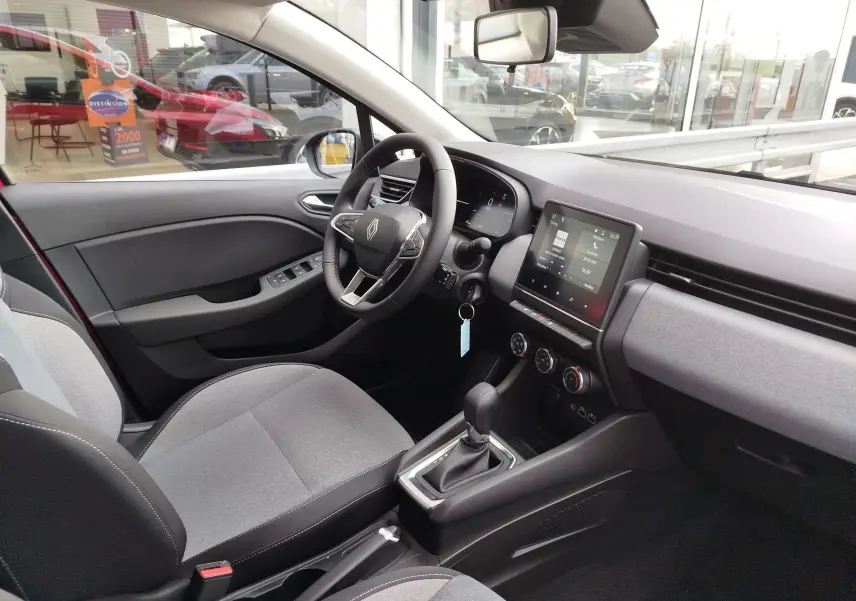 Intérieur côté conducteur de la Renault Clio TCE 90ch X-Tronic Evolution 2025 avec sellerie gris clair et console tactile.