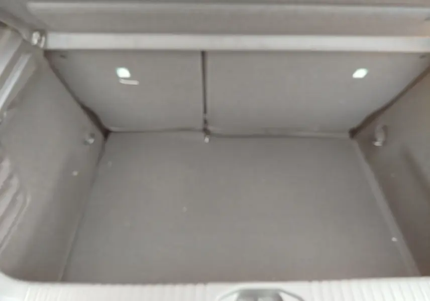 Coffre vide de la Renault Clio TCe 90ch X-Tronic Evolution 2025, vue intérieure arrière avec revêtement gris.