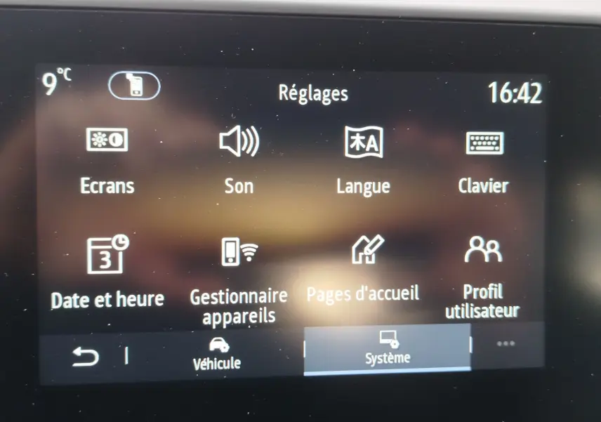 Écran tactile du système de réglages d'une Renault Clio rouge flamme, affichant options son, langue et clavier.