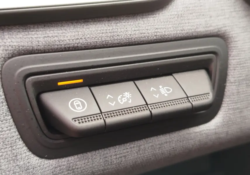 Boutons de réglage intérieur sur tissu gris d'une Renault Clio TCE 90CH X-TRONIC Evolution 2025 rouge flamme.