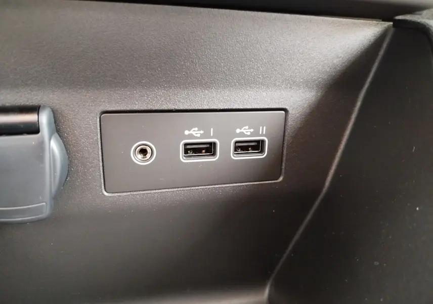 Gros plan sur les prises USB et jack intégrées dans l'habitacle noir de la Renault Clio TCE 90CH X-TRONIC Evolution 2025.