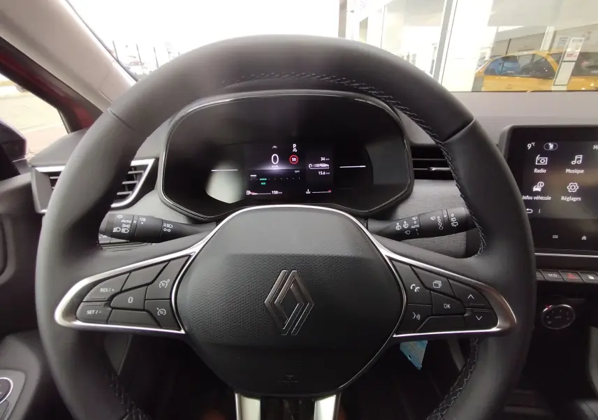 Vue rapprochée du volant noir de la Renault Clio TCE 90CH X-TRONIC Evolution 2025 avec tableau de bord digital.