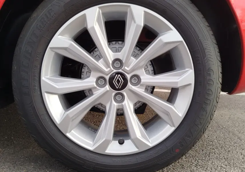 Gros plan sur la jante argentée avec logo Renault d'une Renault Clio rouge flamme, mettant en valeur le pneu Goodyear.