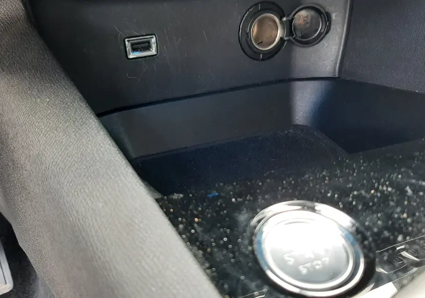 Prise USB et allume-cigare en gros plan dans l'habitacle noir du Peugeot 3008 gris 2020 version Allure.