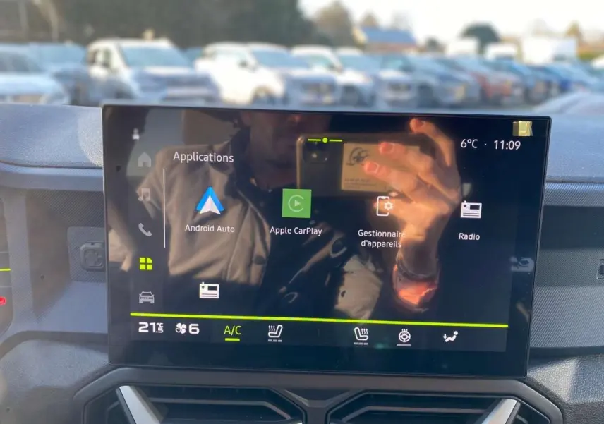 Écran tactile central du tableau de bord du Dacia Duster 2024 affichant les applications Android Auto et Apple CarPlay.