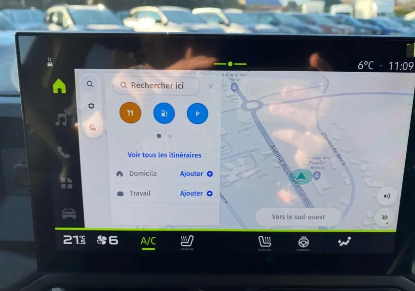 Écran tactile central du Dacia Duster 2024 affichant la navigation et commandes climatisation, intérieur moderne et fonctionnel.