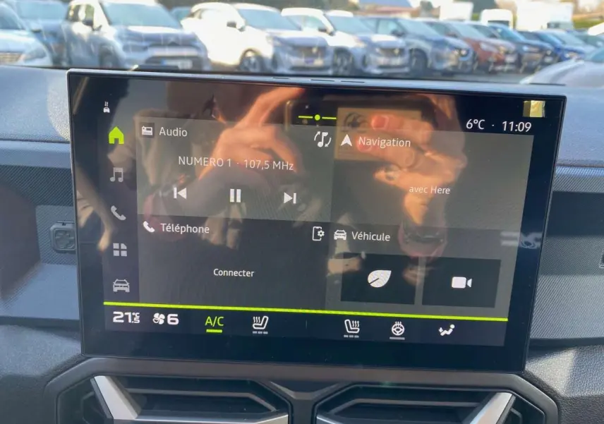 Écran tactile central du tableau de bord du Dacia Duster 2024, affichant radio et navigation, intérieur moderne.