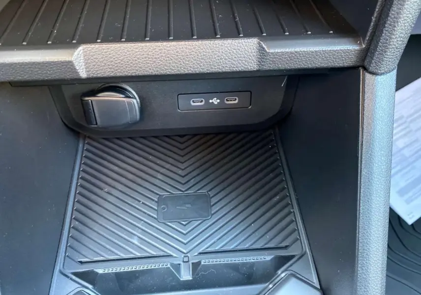 Gros plan sur la console centrale arrière du Dacia Duster 2024 avec prises USB type C et prise 12V noire.