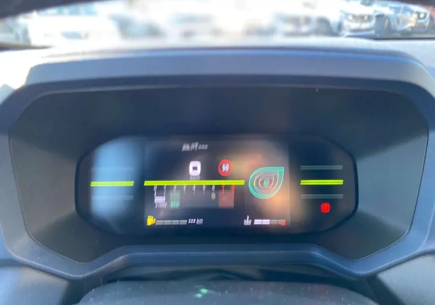 Tableau de bord digital 7 pouces du Dacia Duster 2024 affichant vitesse, jauges et alertes, vue frontale rapprochée.