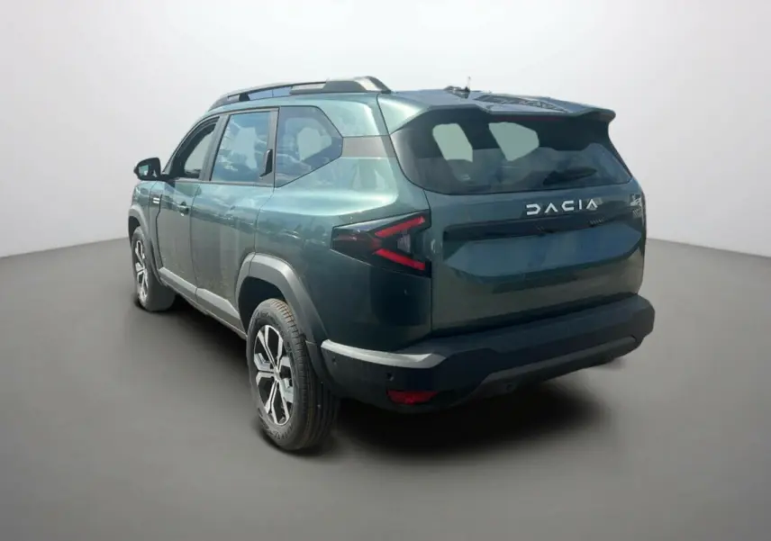 Vue 3/4 arrière droite du SUV Dacia Bigster vert cèdre 2025 avec feux arrière en forme de flèche et logo DACIA visible.