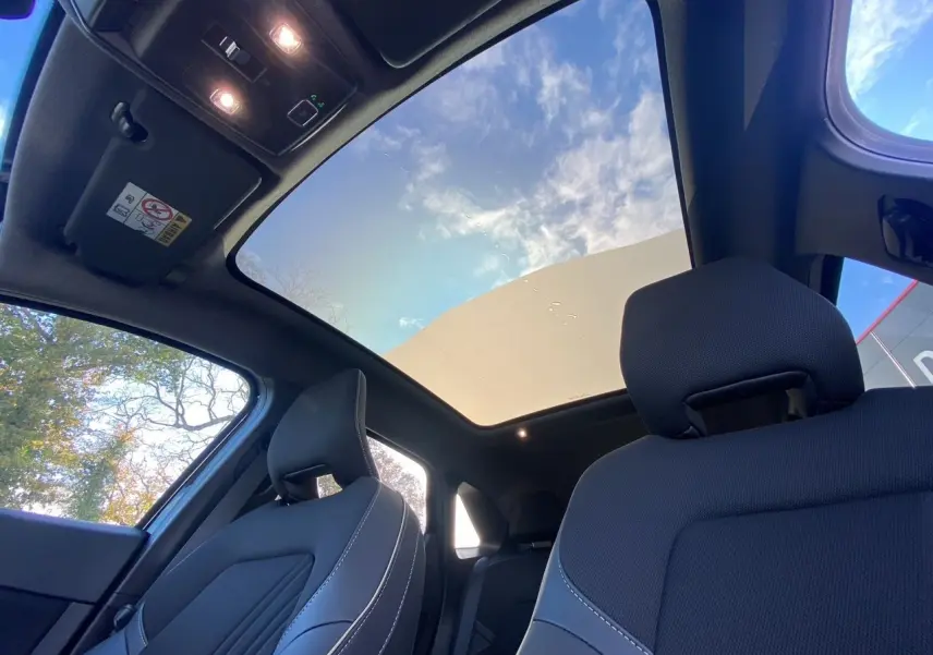 Vue intérieure avant du Renault SYMBIOZ noir étoile, mettant en valeur le toit panoramique Solarbay et les sièges avant en tissu.