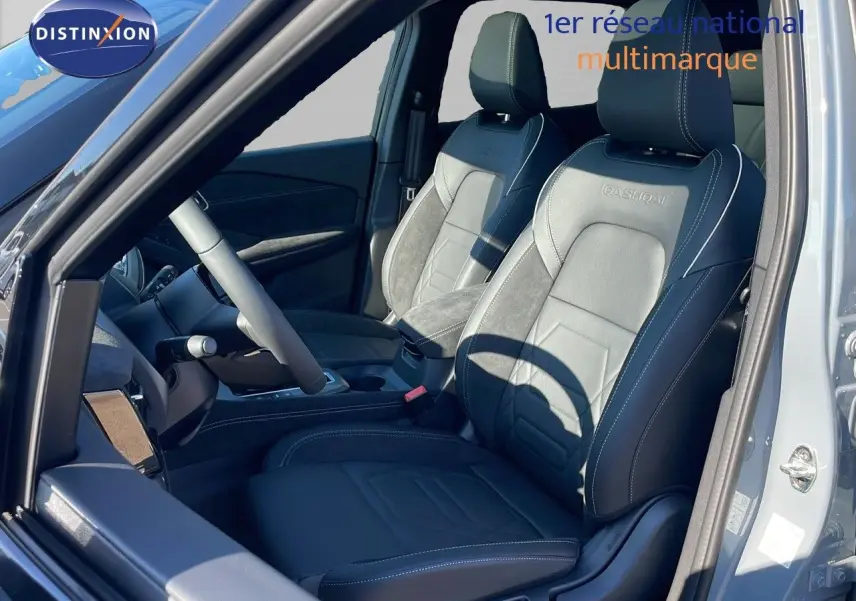 Vue intérieure côté conducteur du Nissan Qashqai 2025, sièges noirs en cuir et alcantara avec surpiqûres blanches et logo Qashqai brodé.