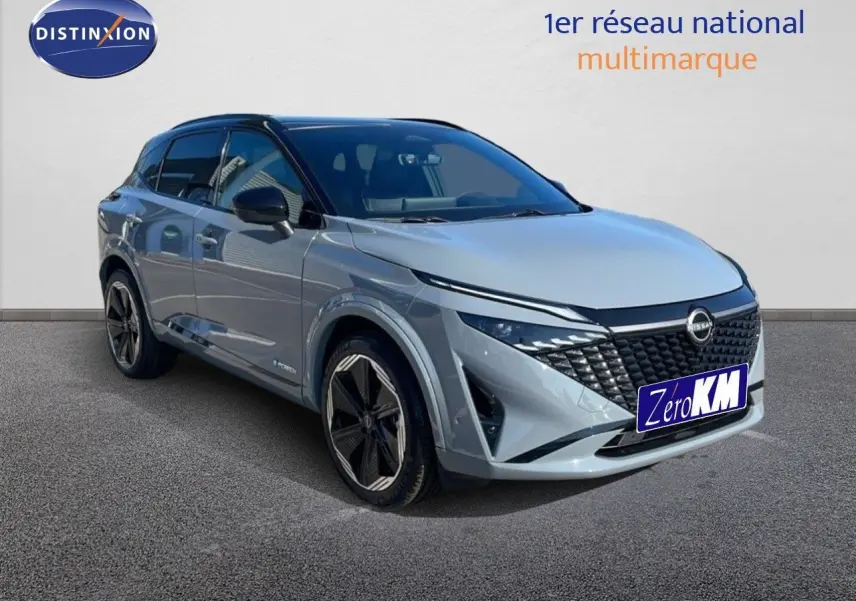 Nissan Qashqai 2025 gris céramique métal avec toit noir, vue 3/4 avant droit mettant en valeur sa calandre distinctive.