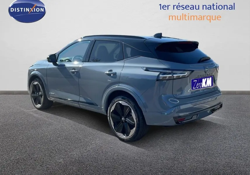Nissan Qashqai 2025 gris céramique avec toit noir, vue 3/4 arrière côté gauche, jantes noires distinctives.
