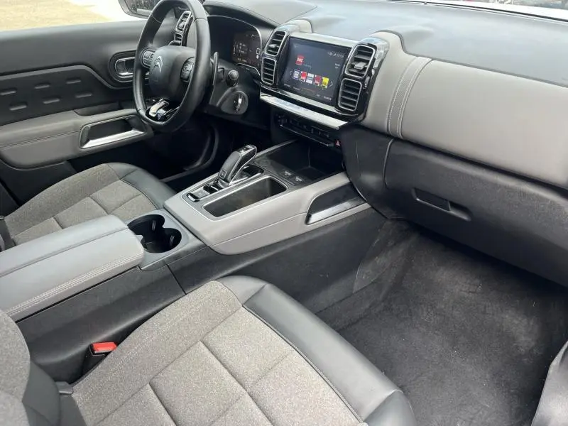 Intérieur avant droit du Citroën C5 Aircross blanc Banquise, avec tableau de bord numérique et sellerie tissu gris et cuir noir.