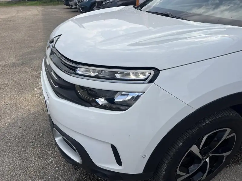 Gros plan sur l'avant droit blanc banquise du Citroën C5 Aircross avec ses phares LED et jante alliage visible.