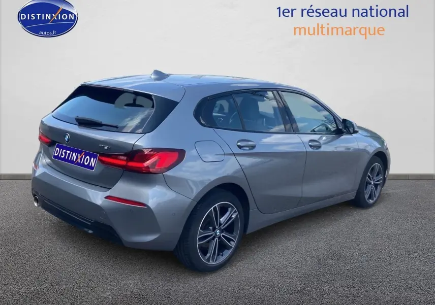 BMW Série 1 gris foncé vue 3/4 arrière côté droit avec jantes alliage et feux arrière LED distinctifs