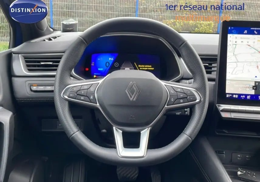Vue frontale du volant noir perforé de la Renault Symbioz E-Tech Full Hybrid 145ch Iconic avec tableau de bord digital et écran tactile.