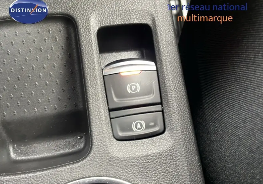 Vue rapprochée des commandes de frein à main électrique et d’assistance au démarrage sur la console intérieure noire.