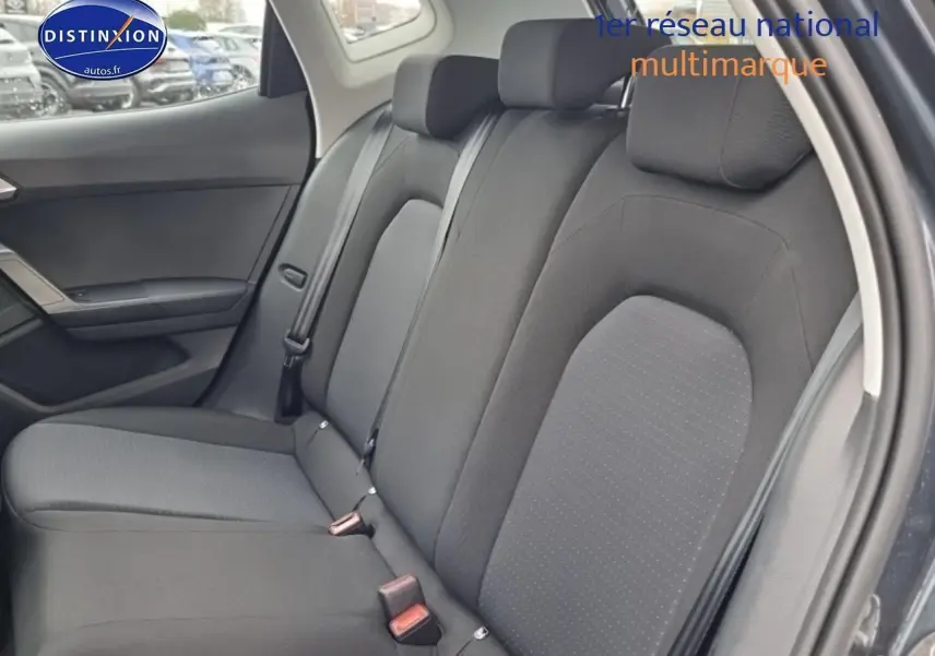 Vue intérieure sur la banquette arrière en tissu gris du SEAT Arona 2025, porte arrière ouverte côté droit.