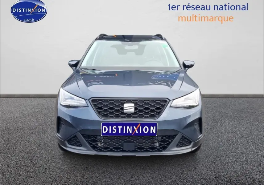 Vue avant d'une SEAT Arona 2025 gris magnétique avec calandre noire et projecteurs full LED allumés.