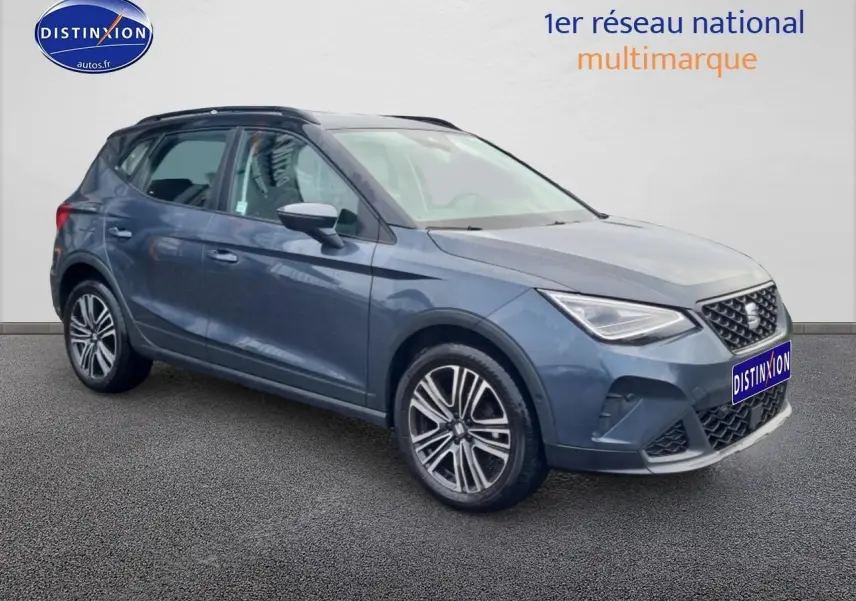 Vue 3/4 avant droite d'un SEAT Arona gris magnétique avec jantes 17 pouces Urban Design et barres de toit noires.