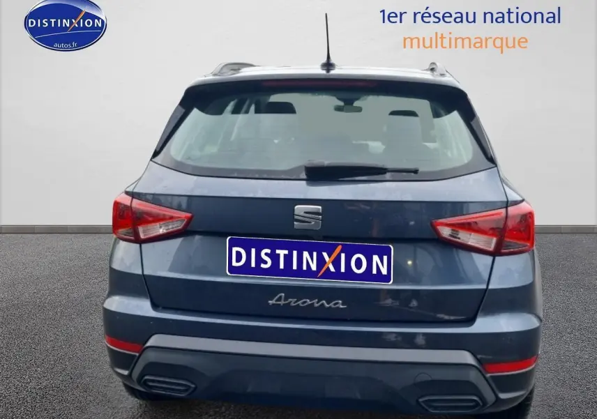Vue arrière d’un SEAT Arona gris magnétique avec feux triangulaires et barres de toit visibles.