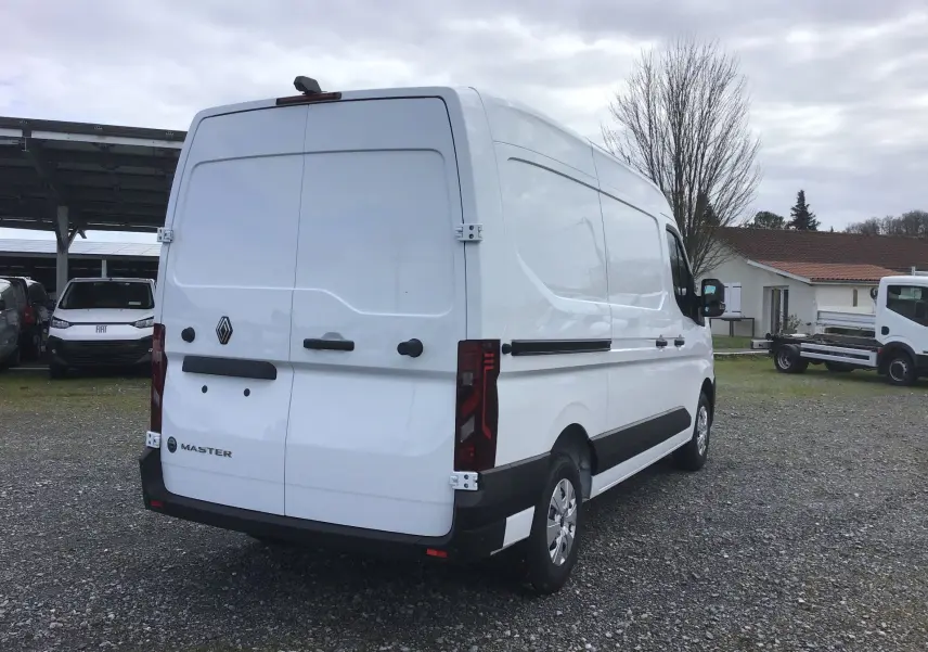 Vue 3/4 arrière droite d’un Renault Master blanc 2025, fourgon utilitaire avec portes arrière battantes et protections noires.