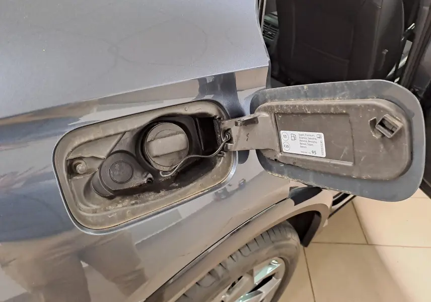 Détail de la trappe à carburant côté gauche d’un CUPRA Formentor gris magnétique avec bouchon essence ouvert.