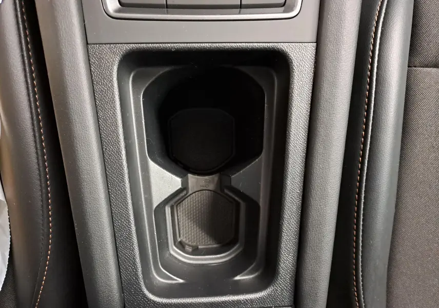 Gros plan sur le porte-gobelets central noir avec surpiqûres cuivrées de l'intérieur du CUPRA Formentor gris magnétique.