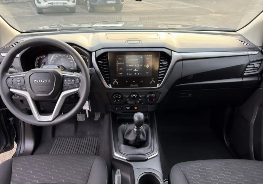 Vue intérieure avant de l'Isuzu D-MAX 2.2 TD gris obsidian, avec tableau de bord moderne et écran tactile central.