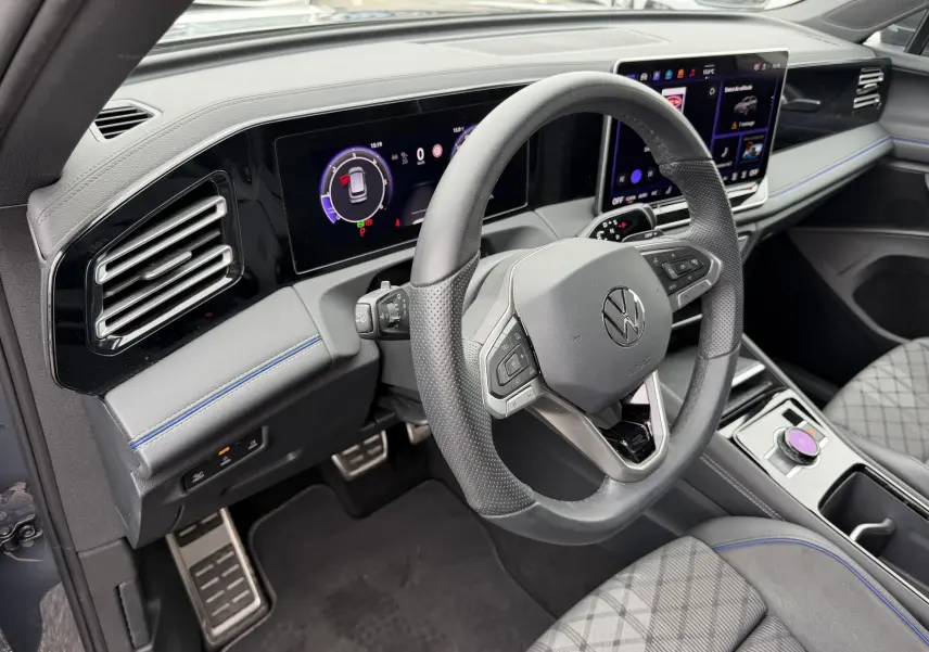 Vue intérieure côté conducteur du Volkswagen Tiguan 2025, volant cuir multifonction et tableau de bord numérique.