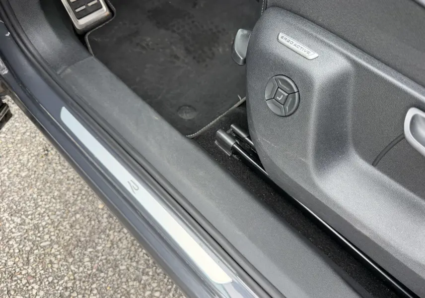 Vue rapprochée côté gauche du siège conducteur gris avec réglage ErgoActive et seuil de porte R du Volkswagen Tiguan 2025.