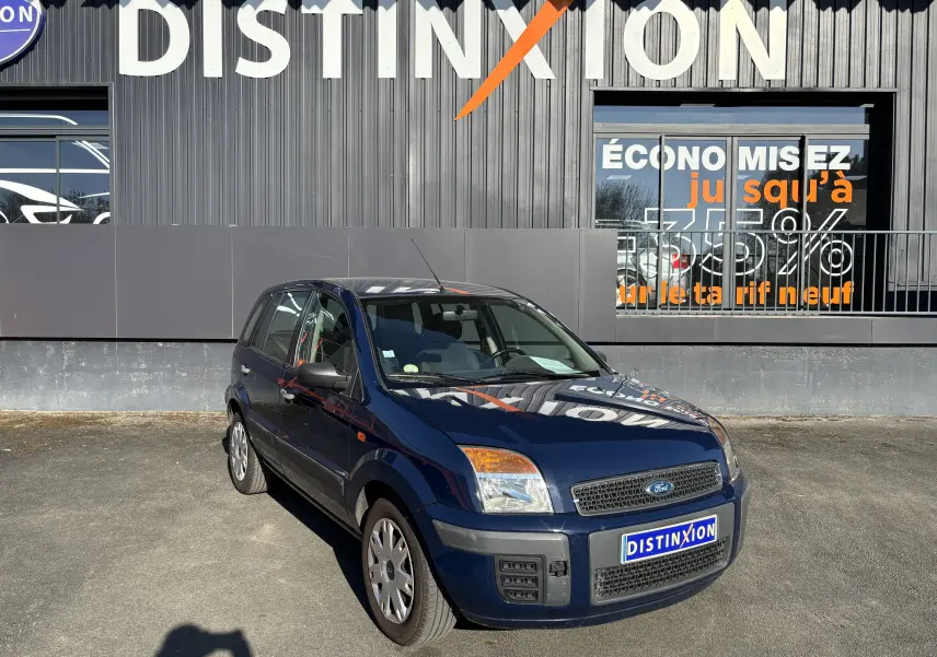 Ford Fusion bleu vue 3/4 avant droit, compacte 5 portes, avec calandre noire et plaques Distinxion.