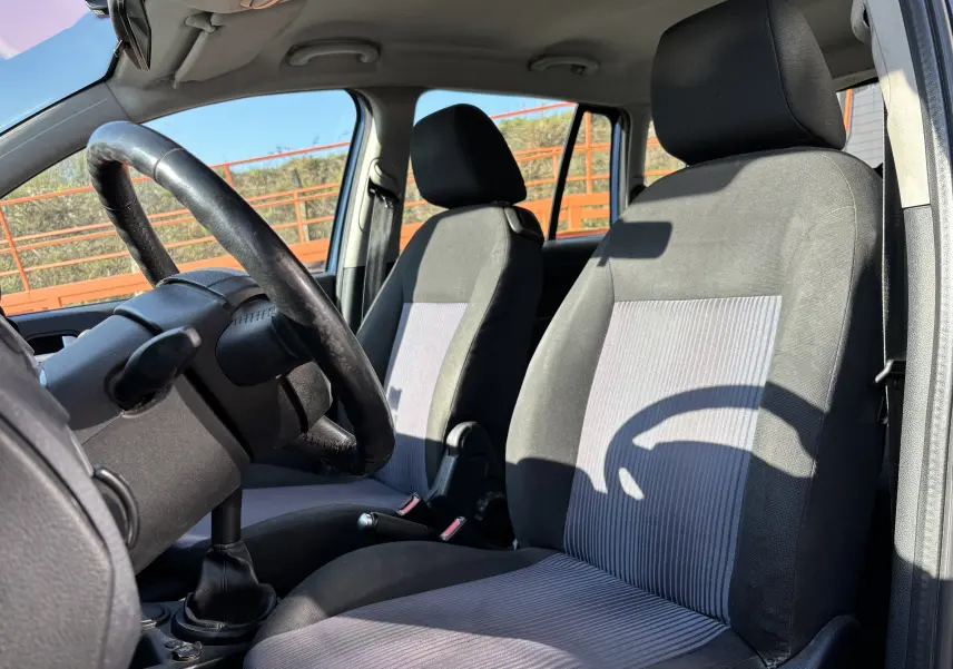 Vue intérieure de la Ford Fusion 2009 montrant les sièges avant gris et noir avec volant et levier de vitesses manuelle.