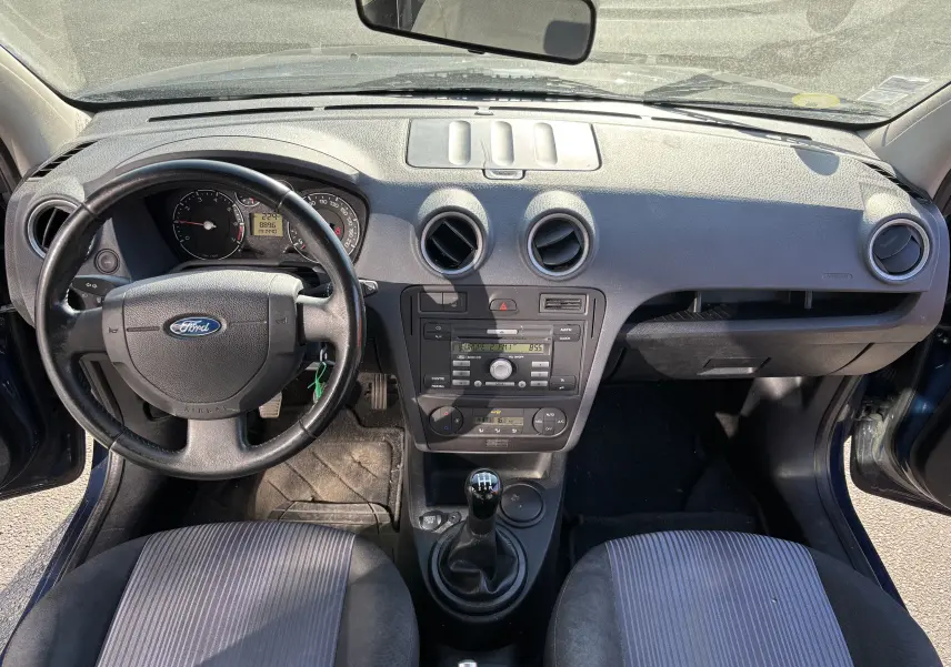 Tableau de bord et volant d'une Ford Fusion 2009 bleu, vue intérieure frontale avec console centrale et sièges avant.