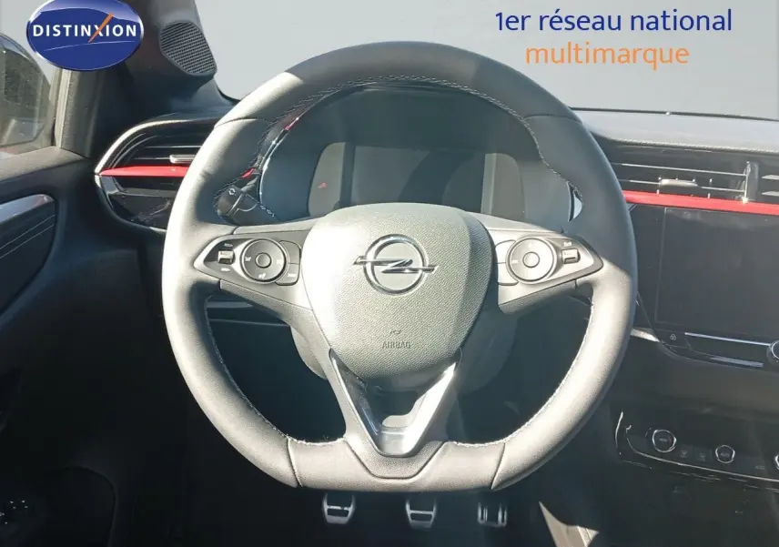 Volant en cuir noir de l'Opel Corsa 2023 avec commandes intégrées et tableau de bord digital partiellement visible.
